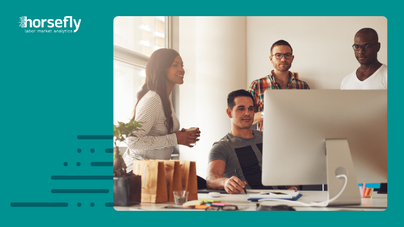 Image shows a group of colleagues working over a computer for the blog - The Growing Impact of the Skill Shortage: How Key Industries are Affected by the Lack of Skilled Workers