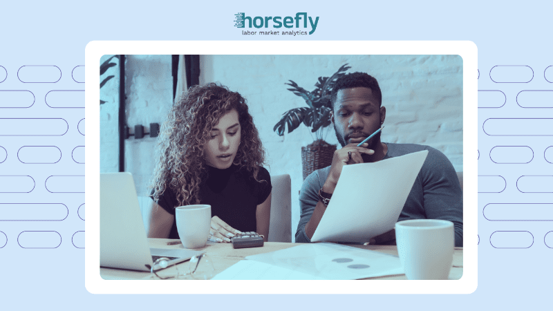 Image shows a man and woman discussing paperwork for the blog - The Growing Impact of the Talent Shortage: How Workforce Planning Pros Can Stay Proactive