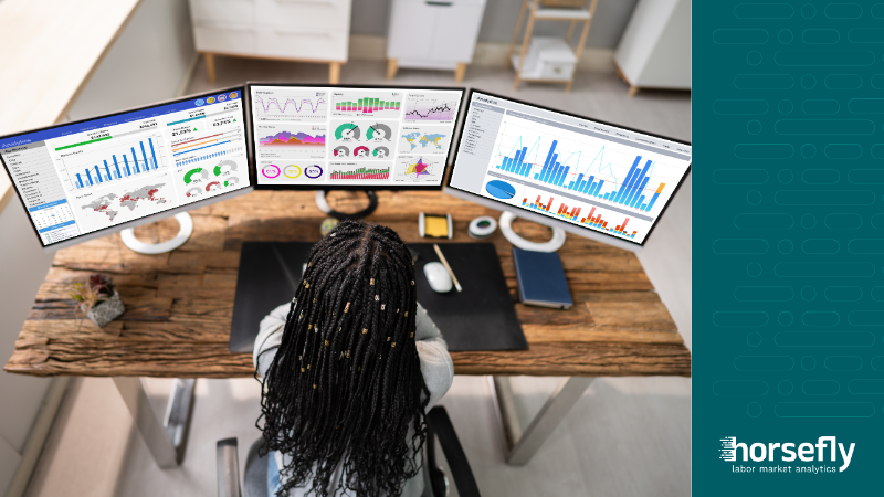 Image shows person from above working across three computer screens with data analytics for the blog - Setting Realistic Diversity Goals with Workforce Data Analytics
