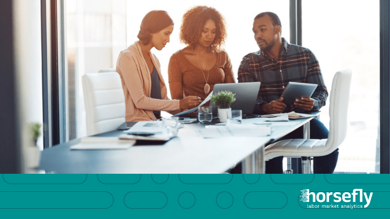Image shows three people sat working around a laptop for the blog - How Talent Analytics Jumpstarts Your Location Strategy